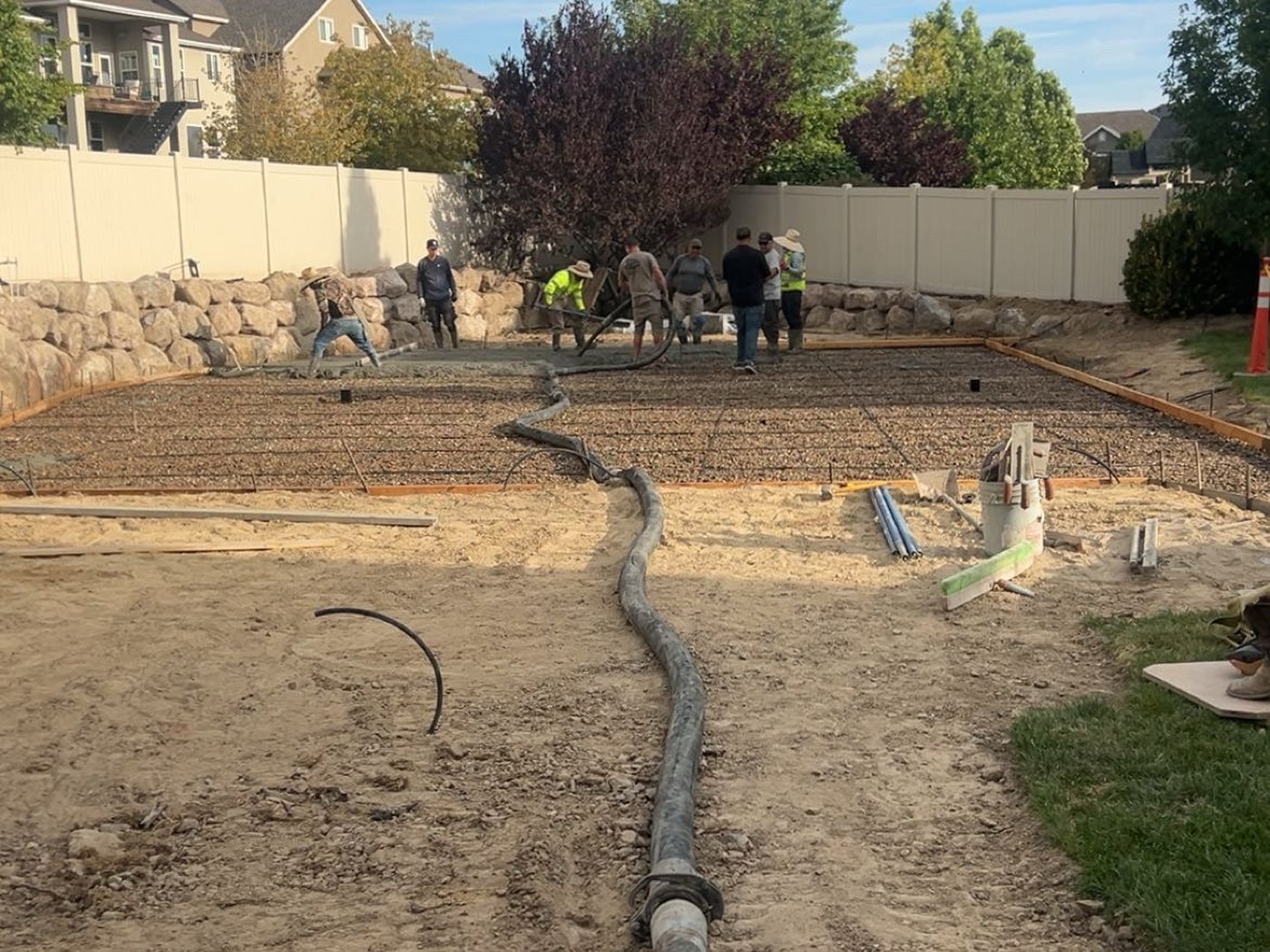 Concrete line pump hose reaching a backyard jobsite in Utah